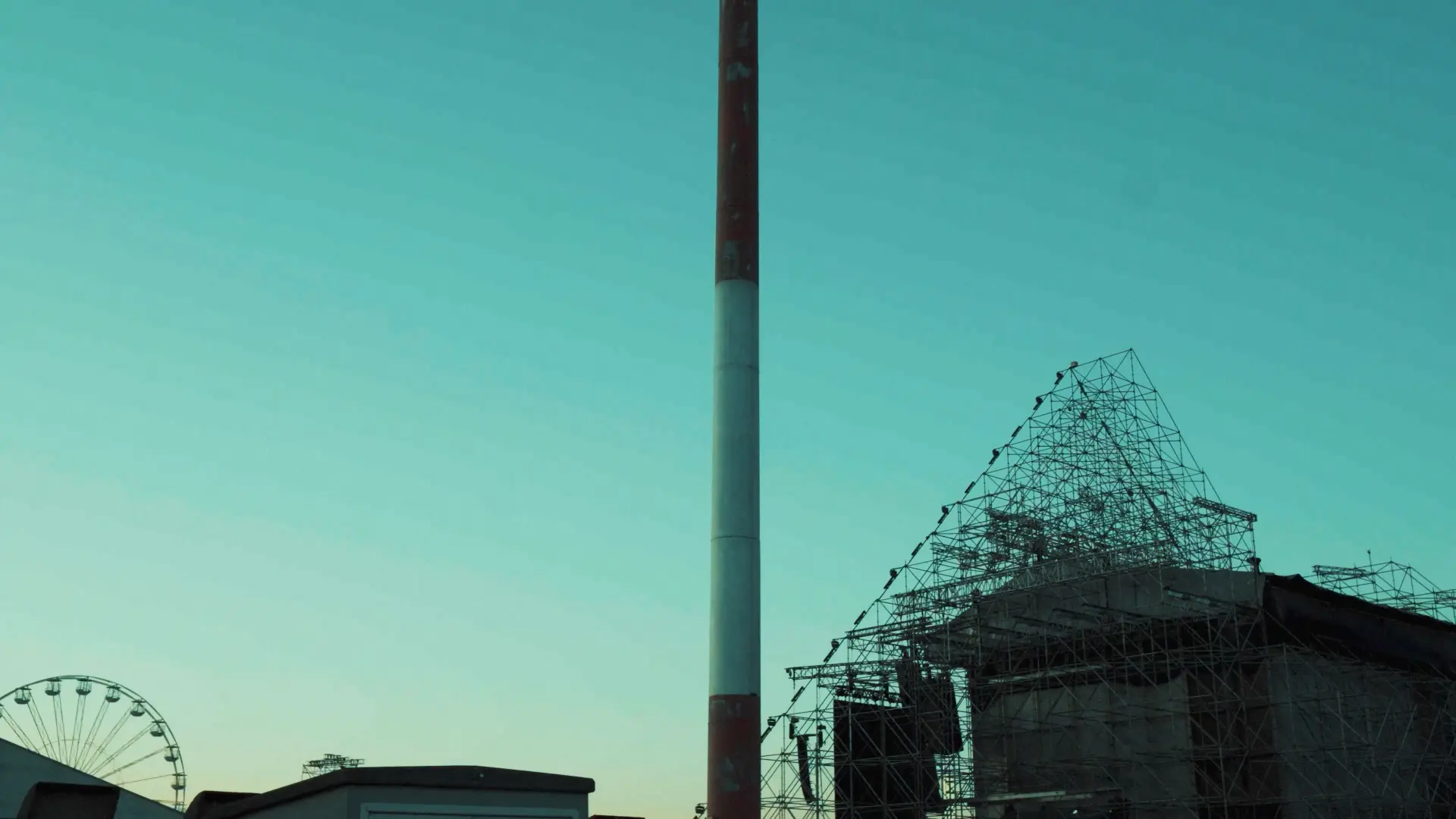 Chimney and festival structure against a teal dusk sky